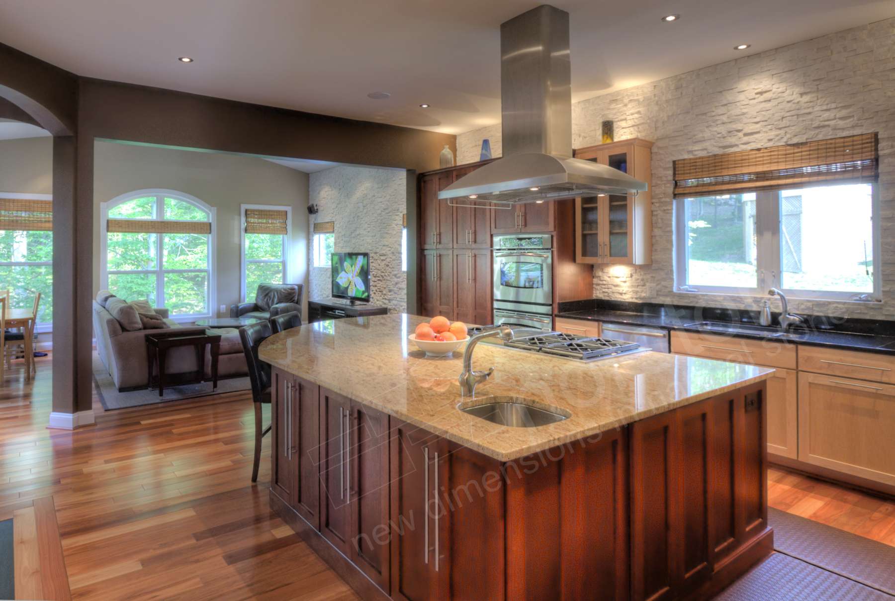 Countertop to ceiling white stacked stone backsplash in a remodeled kitchen with large island